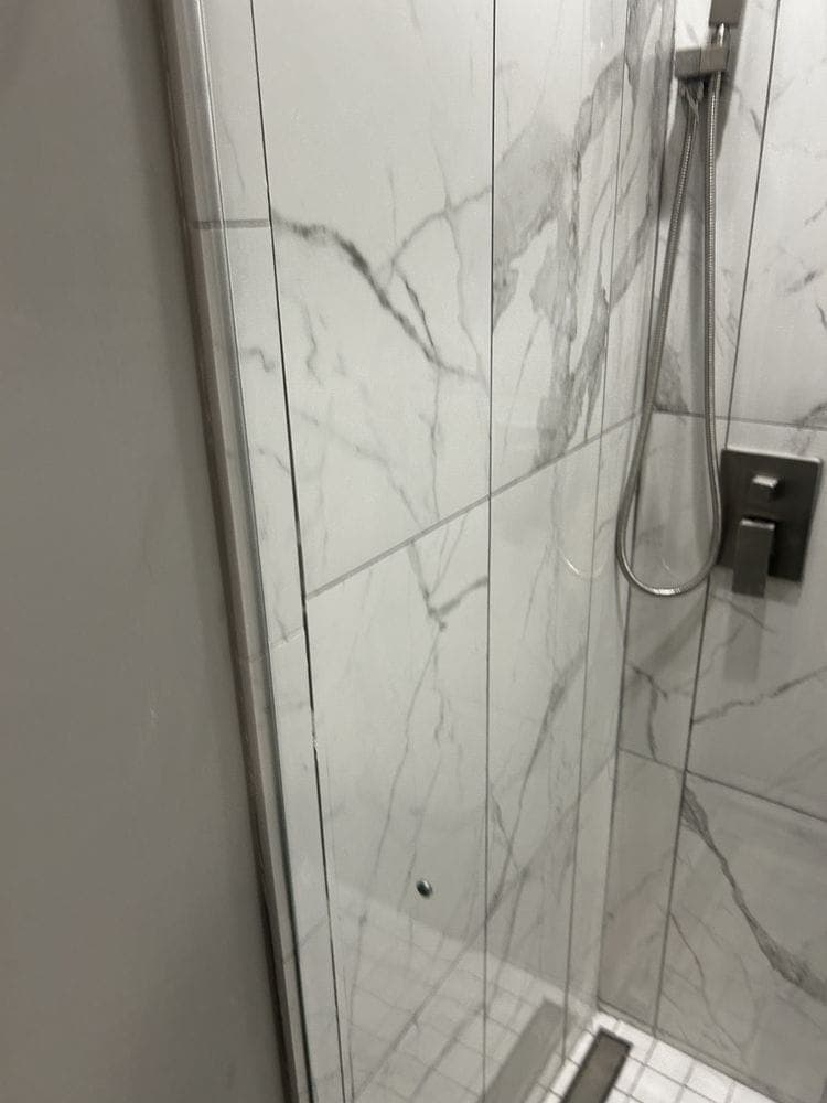 Marble-look tile shower with glass