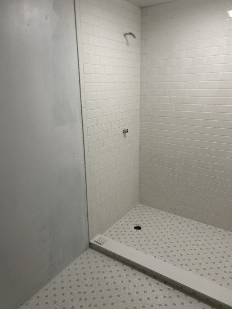 Subway tile shower with a mosaic floor