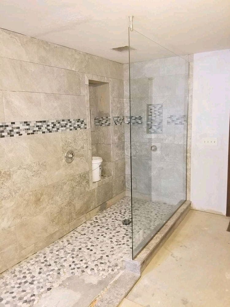 Walk-in shower with a pebble floor